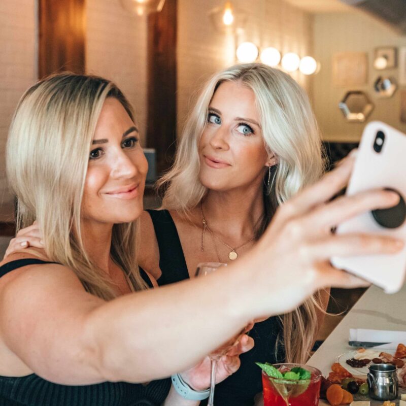 blond girl taking selfie with friend